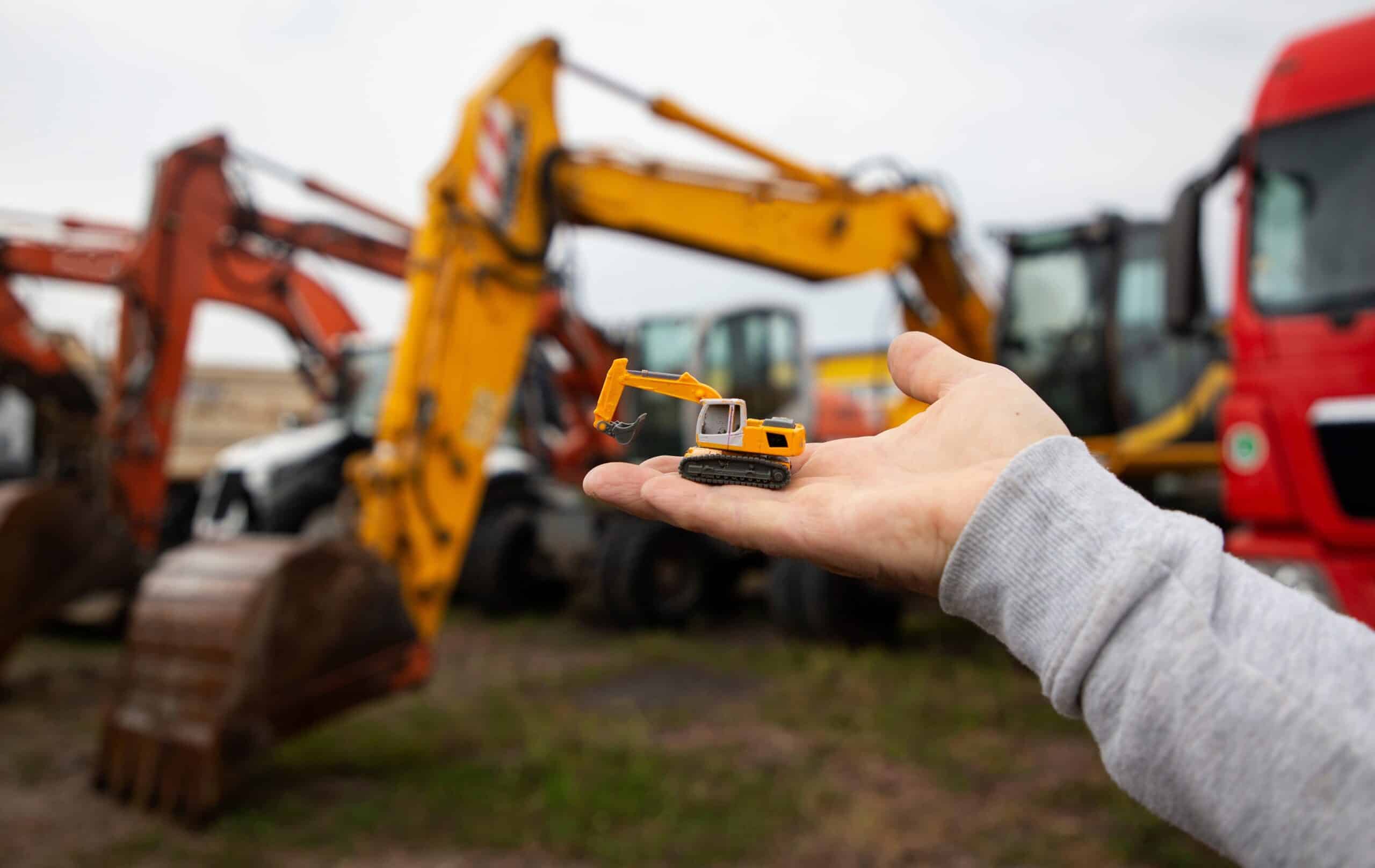 Small Toy Excavator On Mans Palm Ameristrong